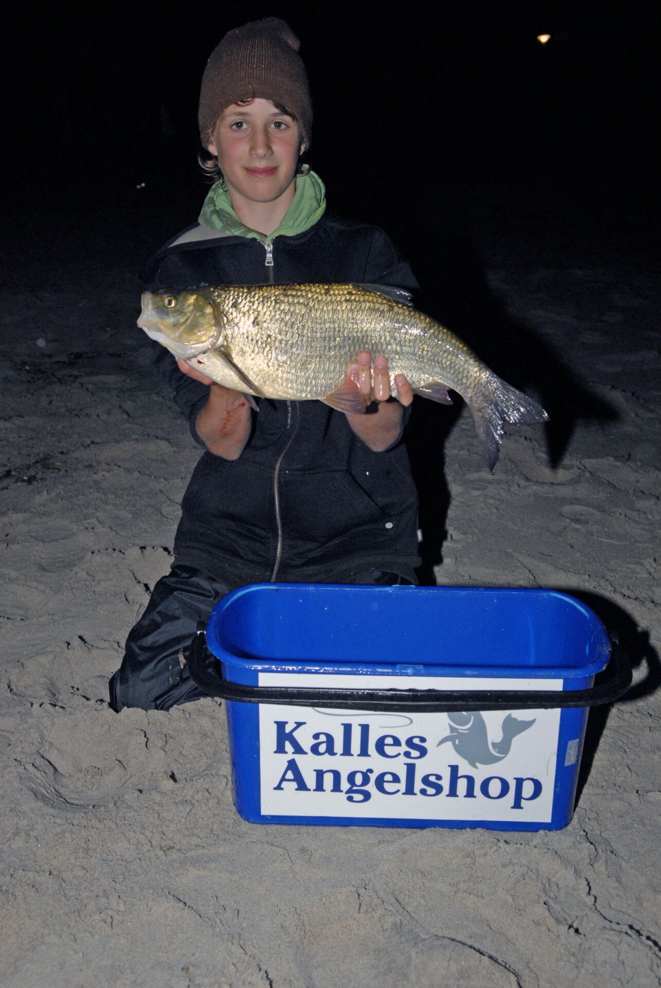 Ole konnte beim Brandungsangeln für Kinder einen 53cm Aland fangen und freut sich über den ungewöhnlichen Fang vom Strand.